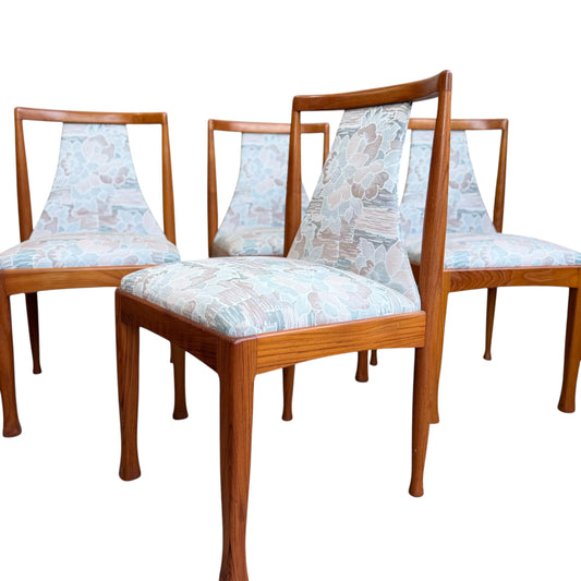 Six Vintage CRO Teak Dining Chairs from the Revive collection, featuring mid-century modern design with patterned upholstered seats and backrests, are arranged in a staggered formation on a white background.