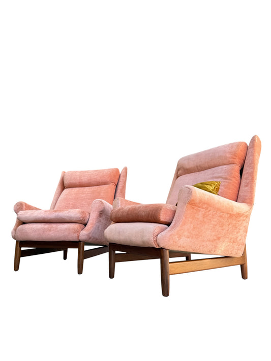Two Mid-Century High-Back/Wingback Armchairs in dusty pink velvet with Blackwood frames are placed side by side. One chair has a yellow cushion, creating a vibrant contrast against the white background. Each armchair is priced individually (Rediscover).