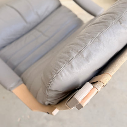 Close-up of a Pair of Tessa Ferrara Swivel Armchairs (Revive) in light gray with visible leather creases, wood armrest details, and beige fabric straps—showcasing classic vintage Tessa Furniture and mid-century Australian style.
