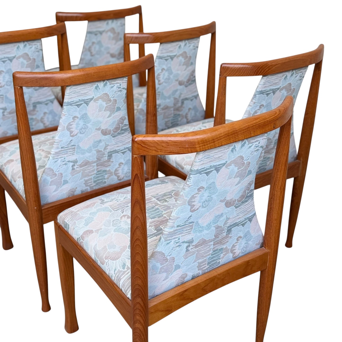 A set of six Vintage CRO Teak Dining Chairs (Revive) with light blue and beige floral upholstered seats and backs, arranged closely together against a white background.