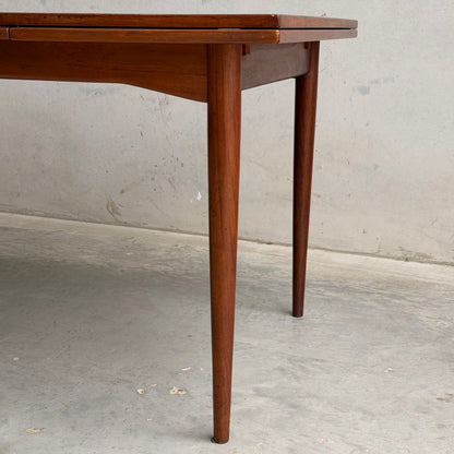 Close-up of the Vintage Mid-Century Parker 109 Nordic Extension Dining Table – Table Only (Revive) with tapered legs and a warm brown finish, set against a light concrete wall and floor for a classic look.