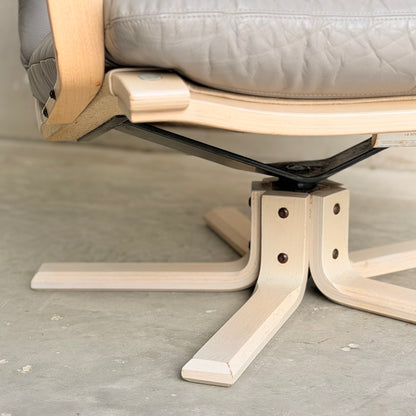 Close-up of the base and lower seat of a Pair of Tessa Ferrara Swivel Armchairs (Revive) with light wood legs, metal swivel, and padded gray cushion—echoing vintage Tessa Furniture and mid-century Australian design.