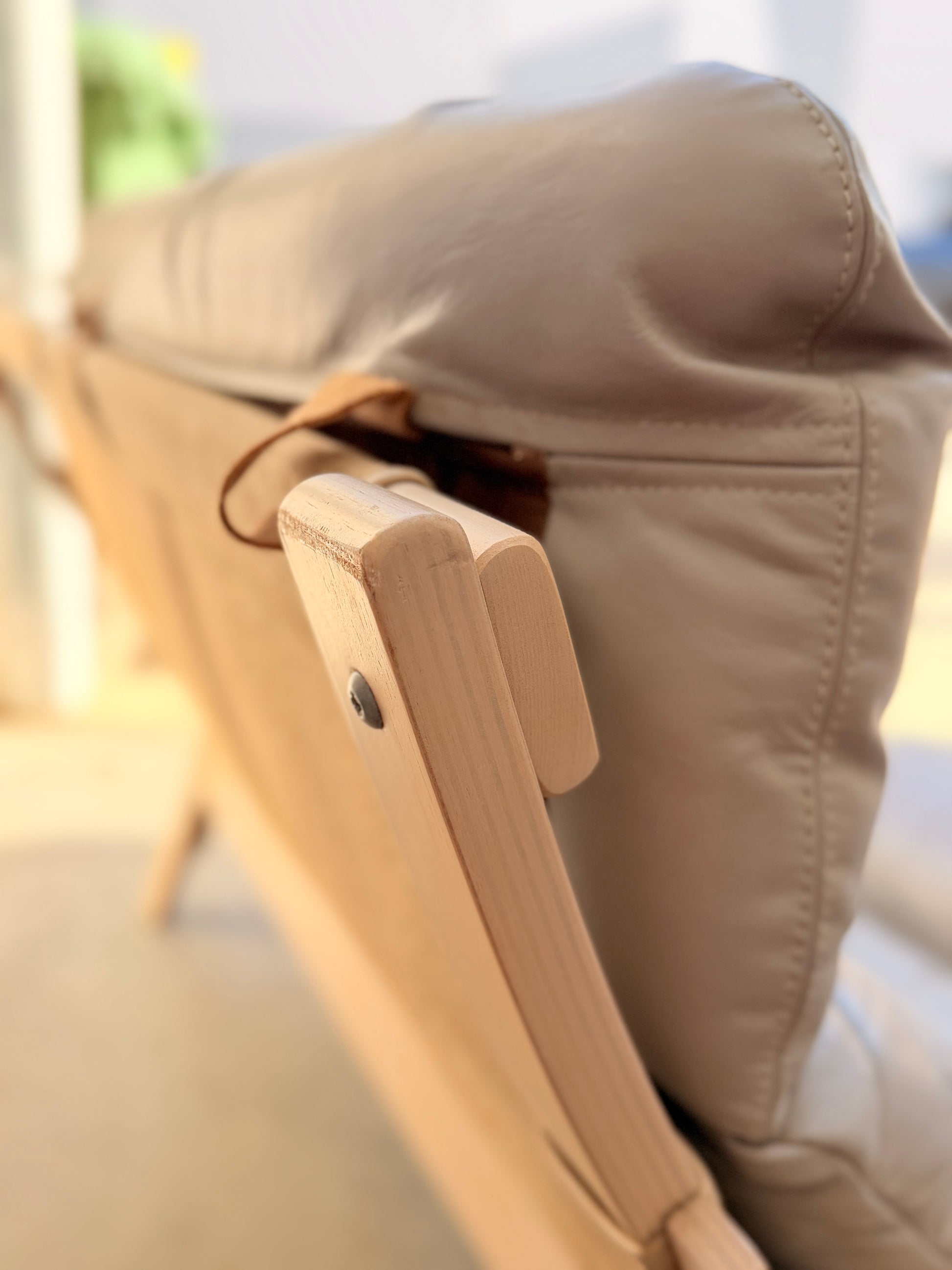 Close-up of the backrest from the Tessa Ferrara Lounge Suite – Complete 5-Piece Set (Revive), showing light leather upholstery and textured wooden frame in soft indoor lighting, evoking classic mid-century design.