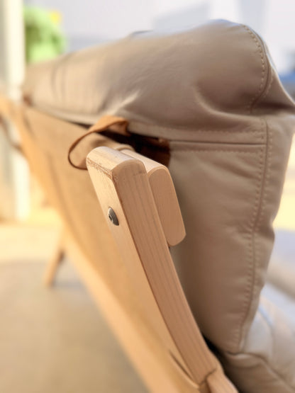 Close-up of the backrest from the Tessa Ferrara Lounge Suite – Complete 5-Piece Set (Revive), showing light leather upholstery and textured wooden frame in soft indoor lighting, evoking classic mid-century design.