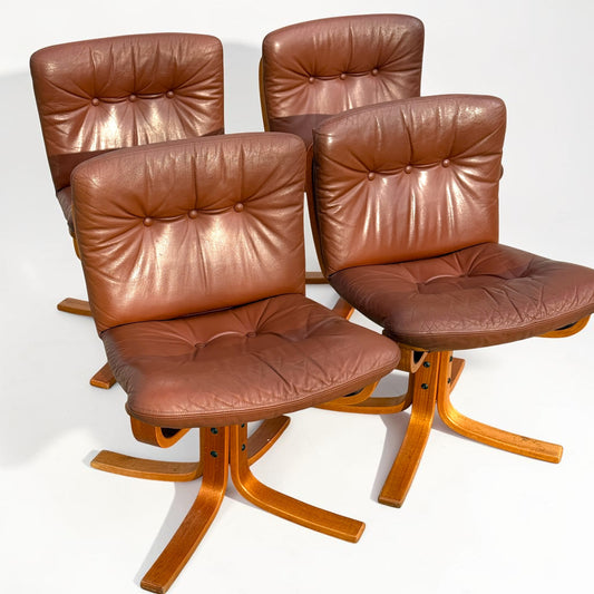 A rare set of 4 vintage Joe Rufenacht lounge chairs upholstered in Howe leather is arranged in two rows on a white background, showcasing curved wooden bases and Scandinavian mid-century modern style.