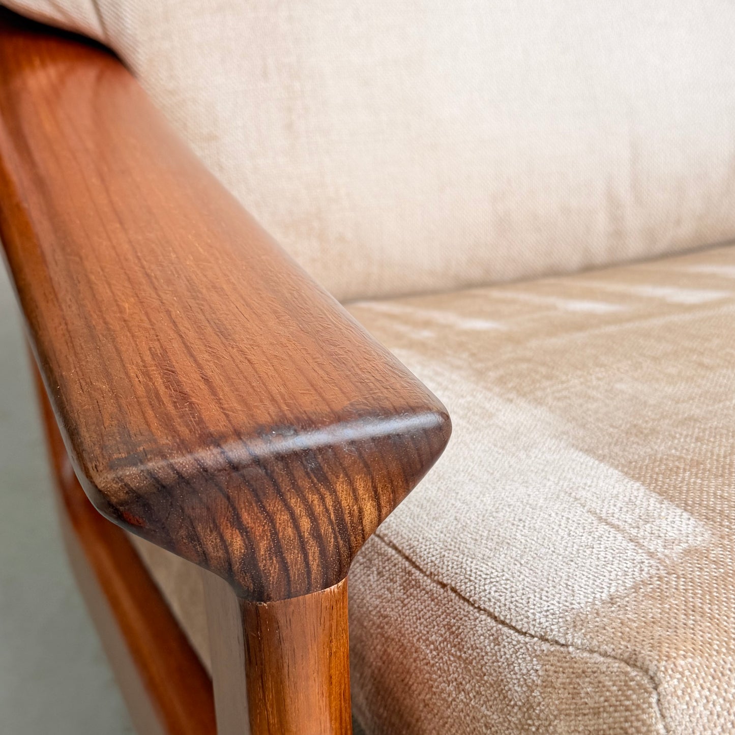 Close-up of the wooden armrest on the Vintage Mid Century Tessa T21 Swivel Chair (Revive), showcasing its smooth grain and cream velvet upholstery for a refined mid-century look.