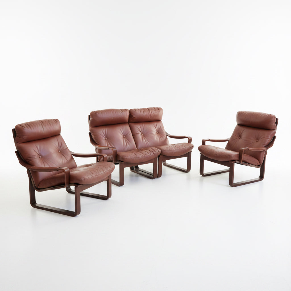 A Tessa T8 Lounge Suite (Revive) modular two-seater sofa and matching armchairs in mid-century modern brown leather, each with tufted cushions, are arranged on a light-colored floor.