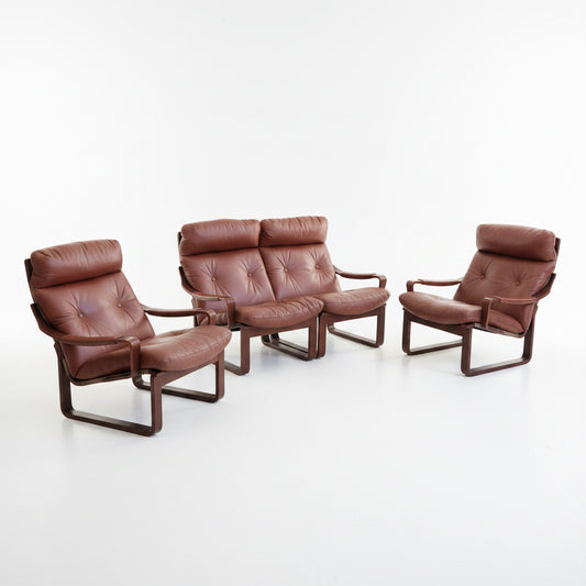 A Tessa T8 Lounge Suite (Revive) modular two-seater sofa and matching armchairs in mid-century modern brown leather, each with tufted cushions, are arranged on a light-colored floor.