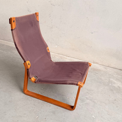 The Tessa Vintage Single No Arm Monaco Armchair – Forest Green (Revive) features a minimalist, angular wooden frame with forest green seat and subtle accents, its exposed joints standing out against a light concrete floor and wall.