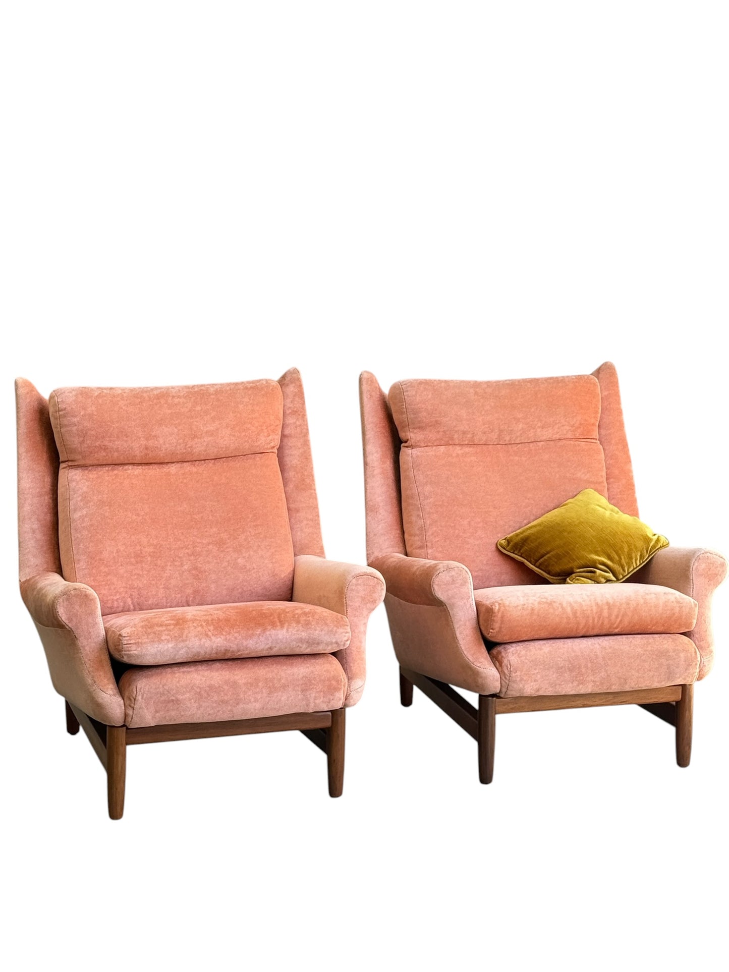 Two Mid-Century High-Back Armchairs in dusty pink velvet with Blackwood frames sit side by side, one styled with a mustard yellow velvet pillow, all set against a white background. Priced individually (Rediscover).