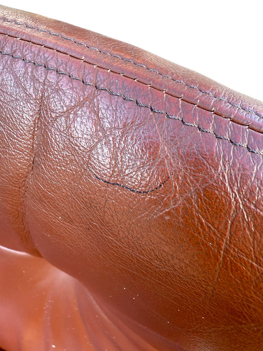 Close-up of worn Howe leather upholstery with creases, wrinkles, and subtle black scuffs. Distinct stitching accents the top edge, reflecting vintage Scandinavian style in this rare set of 4 Joe Rufenacht lounge chairs.