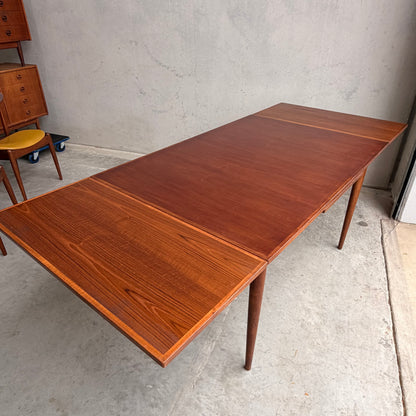 The Vintage Mid-Century Parker 109 Nordic Extension Dining Table (Revive) features tapered legs and two extendable leaves, shown here on a concrete floor against a plain wall.