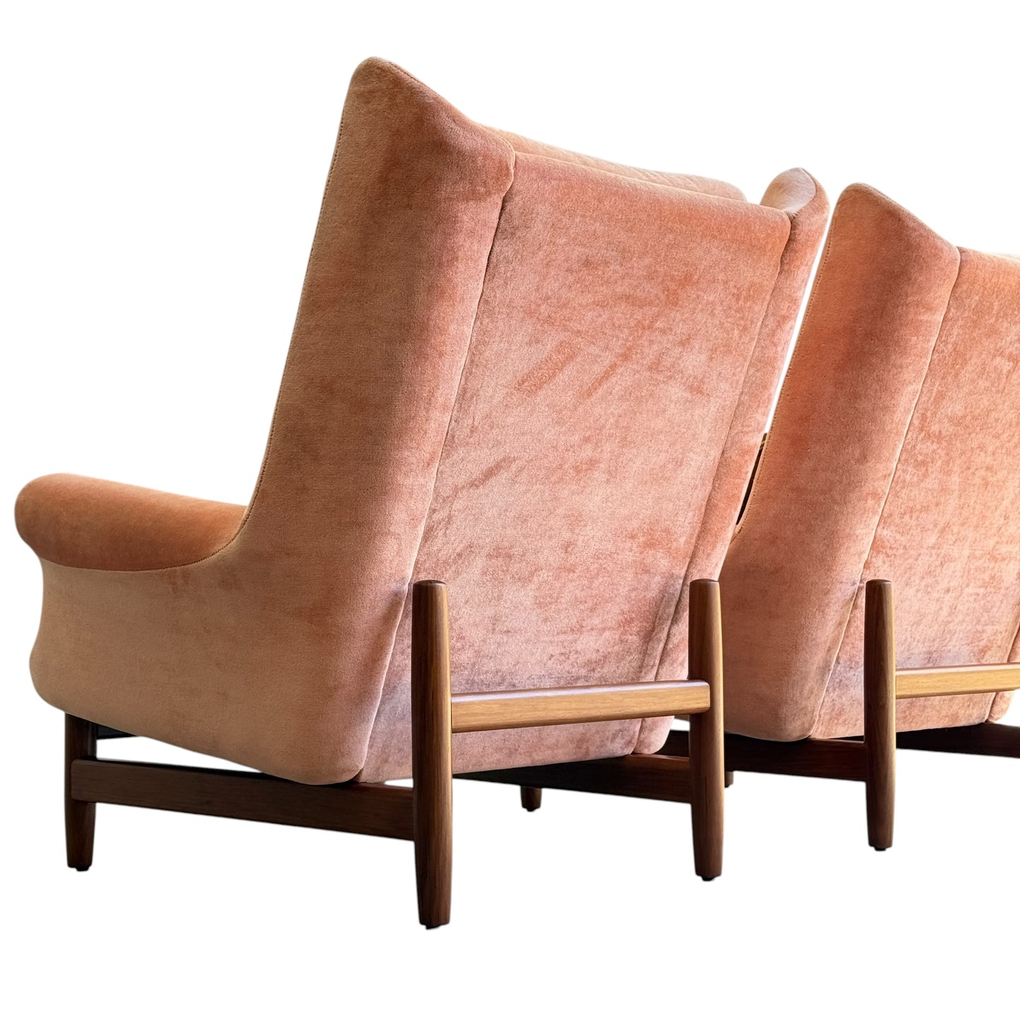 Two Mid-Century High-Back Armchairs in dusty pink velvet with blackwood frames are placed side by side and viewed from the back against a white background.
