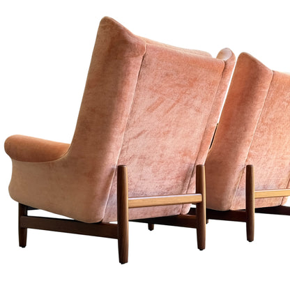 Two Mid-Century High-Back Armchairs in dusty pink velvet with blackwood frames are placed side by side and viewed from the back against a white background.
