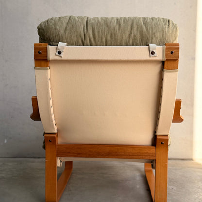 A pair of Tessa Monaco Arm Chairs in sage green corduroy, like new (Revive), with beige fabric backing and wooden frames, shown from behind against a light gray wall.