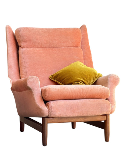 A Mid-Century high-back wingback armchair in dusty pink velvet with Blackwood frames, priced individually, features vintage style and comes with a mustard yellow throw pillow.