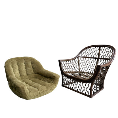 An olive green velvet Adrian Pearsall style 1970s rattan barrel chair sits beside a vintage curved-frame rattan armchair, both set against a white background.
