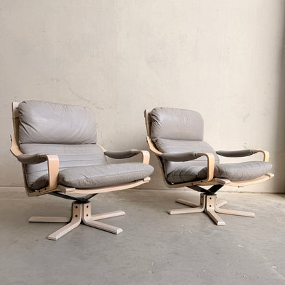 The Tessa Ferrara Lounge Suite – Complete 5-Piece Set (Revive) showcases modern armchairs with light wood frames and light gray cushions, arranged side by side against a plain, light-toned wall on a concrete floor.
