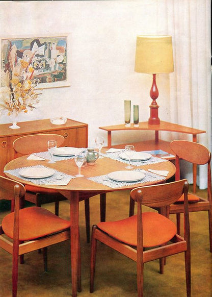 Mid-century modern dining room featuring a wooden table, 107 Parker Matchstick chairs set of 4 (coming soon) with orange cushions, Australian-inspired sideboard, vase of flowers, corner lamp, art on white walls, and curtains.