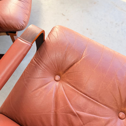 Close-up of the Tessa T8 Lounge Suite modular two-seater sofa & armchairs (Revive): vintage brown leather with creases, central button tuft, and wooden armrest, capturing iconic mid-century modern style on a light floor.