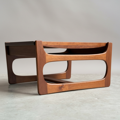 The Ultra Rare Gerald Easden Coffee Table in Blackwood with a sleigh leg base features clean lines and rounded rectangular side cutouts, inspired by Australian vintage design, set on a smooth concrete floor against a neutral background.