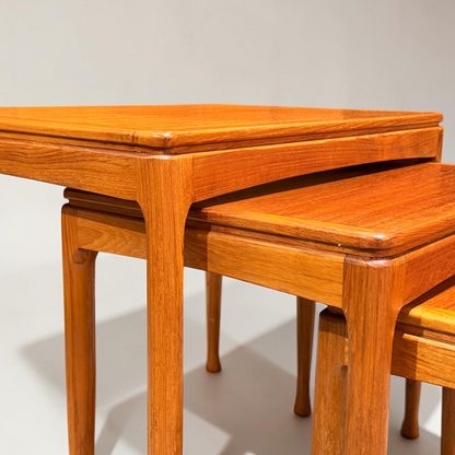 Close-up of rare Alpa Teak Nesting Tables – Set of 3, Australian Mid-Century Modern (Revive), with rounded edges and polished finish. Stacked to highlight their clean, minimalist design against a plain light background.