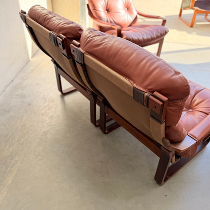 Two Tessa T8 Lounge Suite modular armchairs (Revive) rest on a smooth floor with sunlight casting soft shadows; one armchair is fully visible, while the other appears partially in the background.