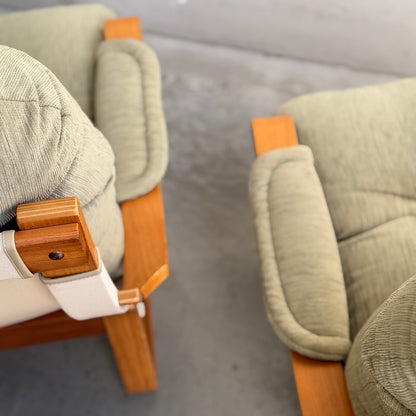 A Pair of Tessa Monaco Arm Chairs - Sage Green Corduroy Like New (Revive) with wooden arms are placed side by side on a gray floor, viewed from above at an angle.