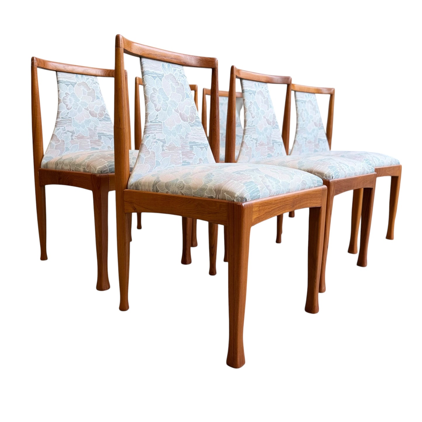 Six Vintage CRO Teak Dining Chairs (Revive) with light floral upholstered seats and backs, featuring clean lines reminiscent of classic mid-century modern Australian design, arranged in staggered rows on a white background.
