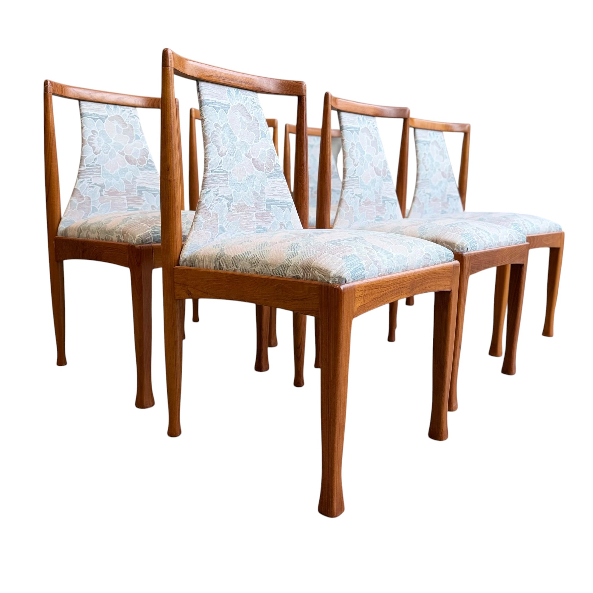 Six Vintage CRO Teak Dining Chairs (Revive) with light floral upholstered seats and backs, featuring clean lines reminiscent of classic mid-century modern Australian design, arranged in staggered rows on a white background.