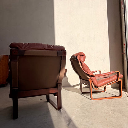 A modular two-seater sofa and armchairs from the Tessa T8 Lounge Suite (Revive) sit in a sunlit room with bare walls and a concrete floor, radiating mid-century modern style—one piece highlighted by light, another fading into shadow.