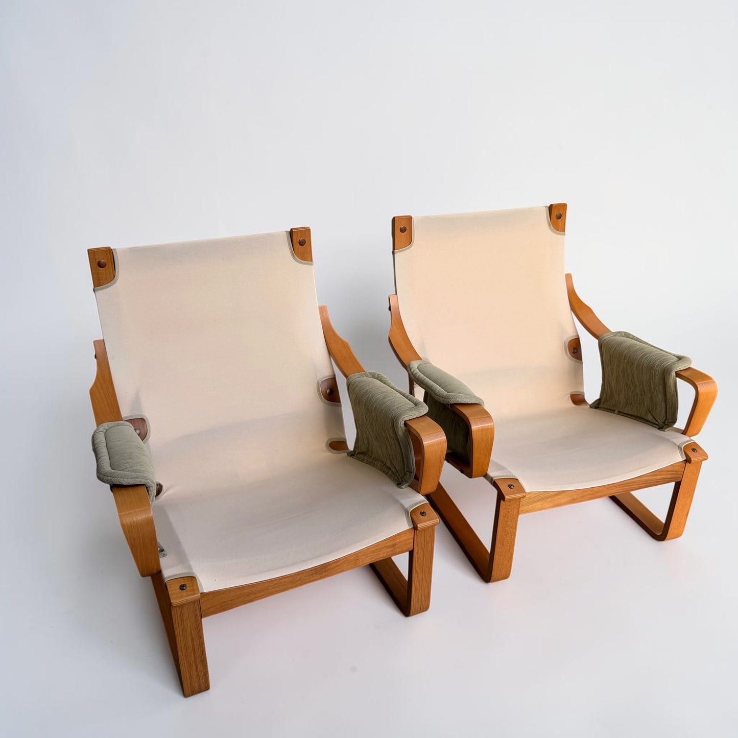 A pair of Tessa Monaco Arm Chairs, like new in sage green corduroy, with light wood frames and beige fabric seats and backs, shown against a plain white background.