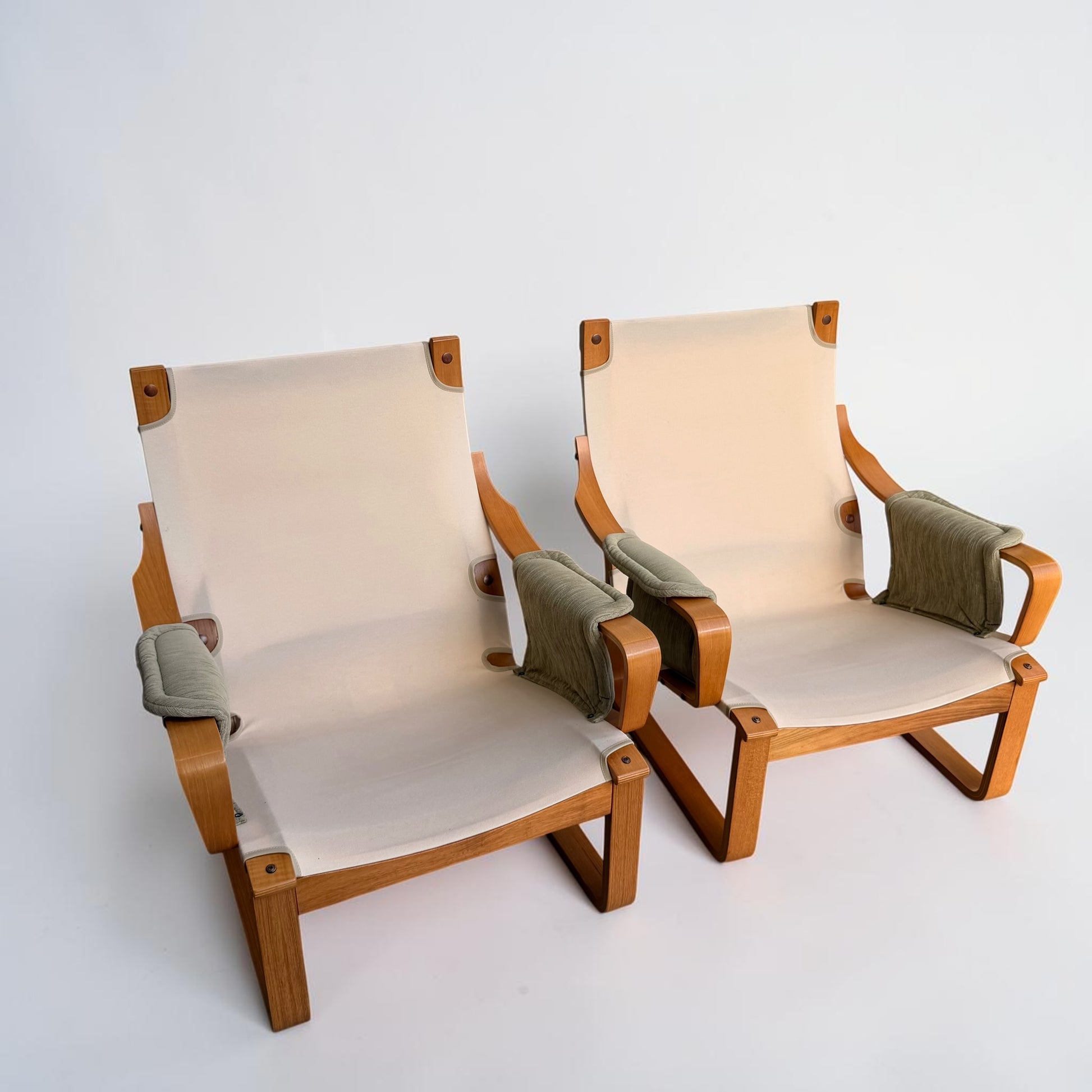 A pair of Tessa Monaco Arm Chairs, like new in sage green corduroy, with light wood frames and beige fabric seats and backs, shown against a plain white background.