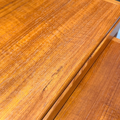 Close-up of a Rare set of Alpa Teak Nesting Tables – Set of 3, Australian Mid-Century Modern. Warm golden-brown finish with visible wood grain; one table has a noticeable scratch across the top surface.