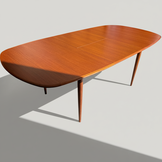 The Fully Restored Parker No.92 D End Dining Table (Rediscover) is a mid-century modern oval wooden table with smooth lines and tapered legs, inspired by vintage Australian design, shown on a plain background with light and shadow.