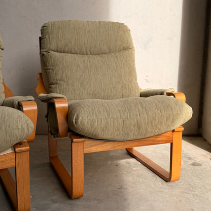 A pair of Tessa Monaco Arm Chairs in sage green corduroy, like new (Revive), with light wooden frames sits on a concrete floor in sunlight; one chair is fully visible, the other partially shown on the left.