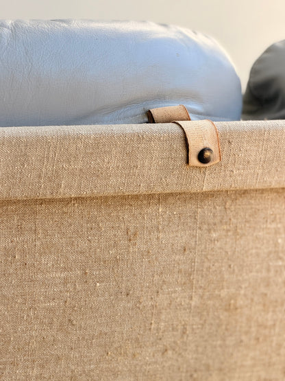 Close-up of the back of a beige fabric chair from the Tessa Ferrara Lounge Suite – Complete 5-Piece Set (Revive), featuring leather strap and metal rivet details with light grey headrest—showcasing Fred Lowen's mid-century modern design.