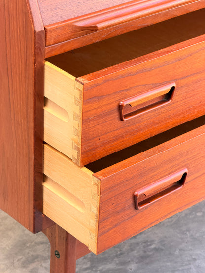 Close-up of the Mid Century Modern Danish Arne Wahl Iversen Model 68 Teak Secretary Desk by Vinde Møbelfabrik, featuring two open drawers with dovetail joints and integrated handles, set on a smooth gray floor.