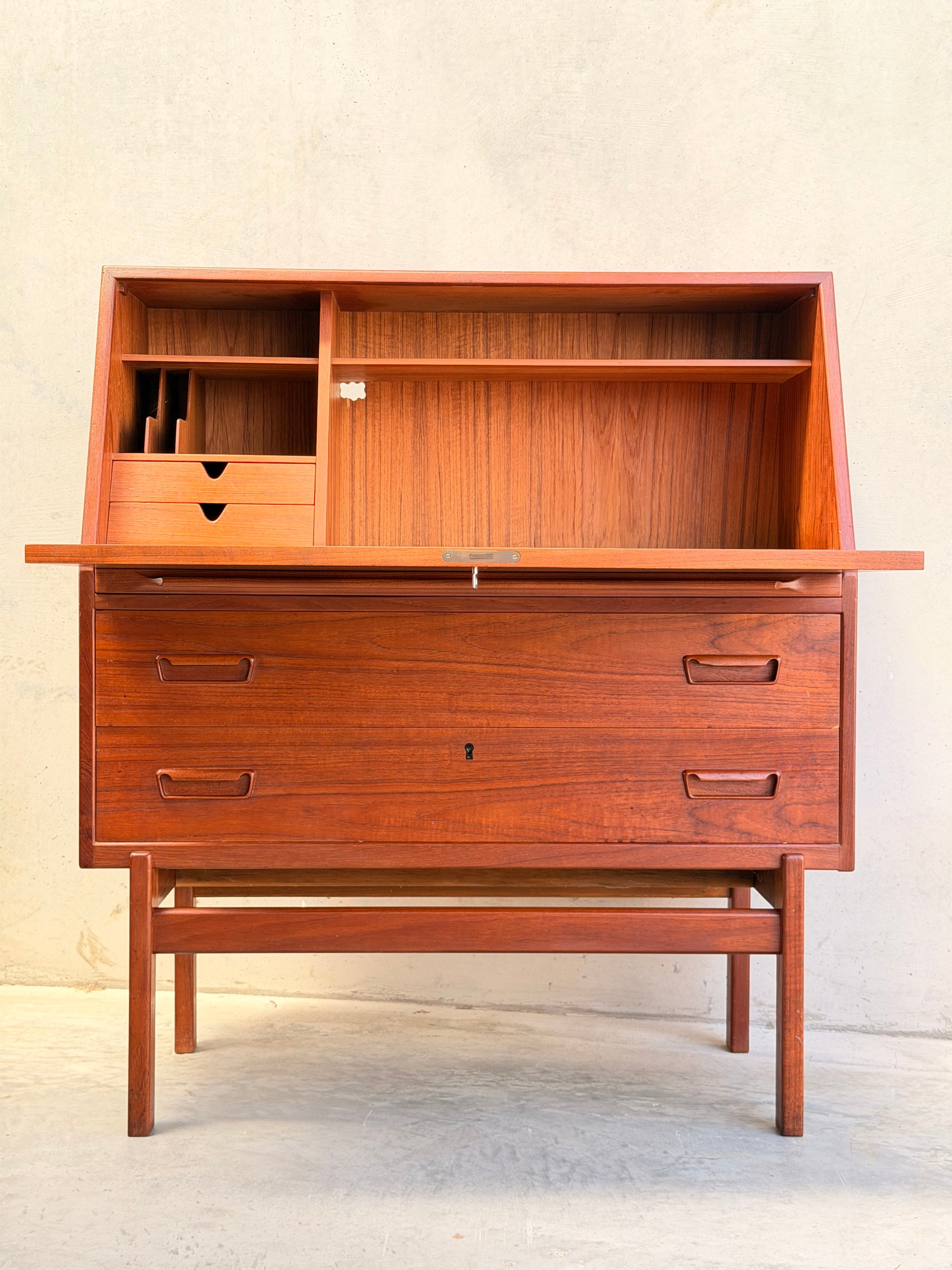 The Mid Century Modern Danish Arne Wahl Iversen Model 68 Teak Secretary Desk by Vinde Møbelfabrik showcases open compartments, small drawers, and spacious lower storage on four legs for a classic vintage style.