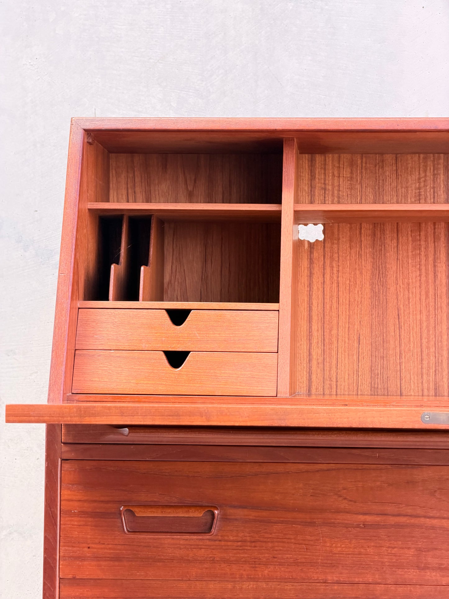 A close-up of the Mid Century Modern Danish Arne Wahl Iversen Model 68 Teak Secretary Desk by Vinde Møbelfabrik, featuring compartments, shelves, and two small drawers in warm reddish teak against a plain light wall.