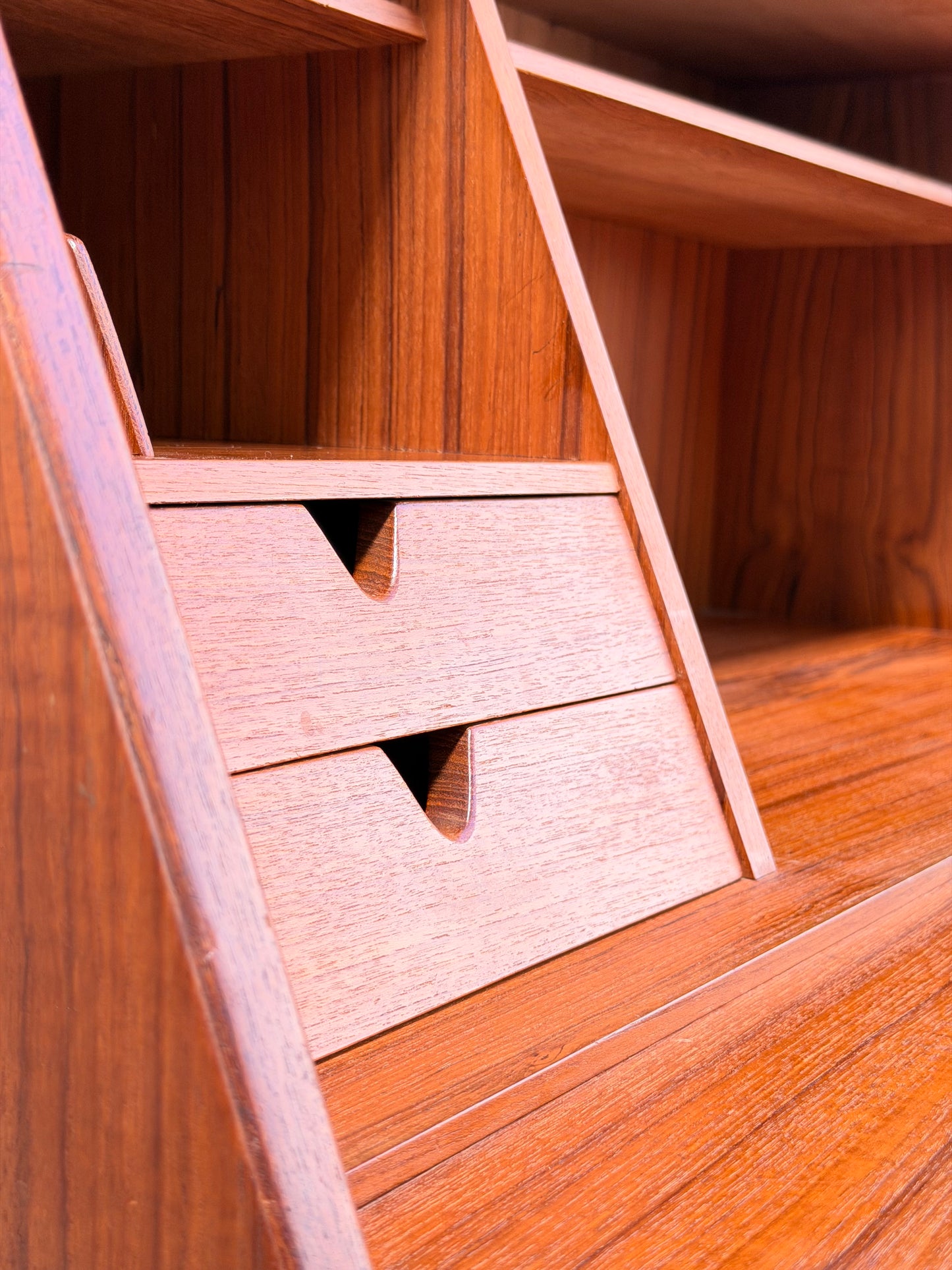 Close-up of the Mid Century Modern Danish Arne Wahl Iversen Model 68 Teak Secretary Desk by Vinde Møbelfabrik, featuring two small drawers with triangular cut-out handles and open shelves above that showcase its elegant wood grain.