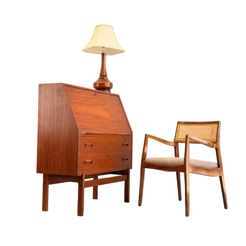 A Mid Century Modern Danish Arne Wahl Iversen Model 68 Teak Secretary Desk by Vinde Møbelfabrik stands beside a wooden chair with woven cane back and cushioned seat, both set against a plain background.