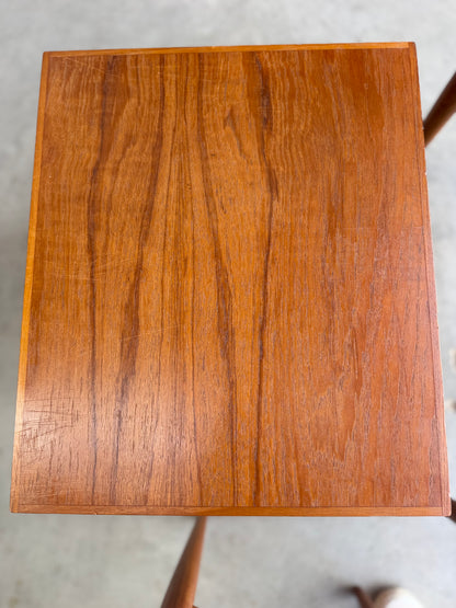 A close-up of the top surface of a Noblett Mid-Century Floating Teak Nesting Table – Circa 1960s (Revive), highlighting its warm, reddish-brown finish, natural grain pattern, and Danish-inspired design against a softly blurred background.
