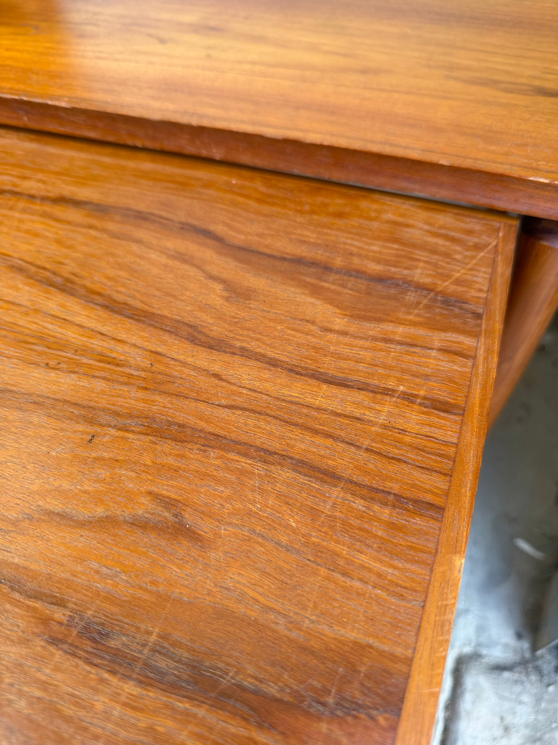A close-up of a Noblett Mid-Century Floating Teak Nesting Table – Circa 1960s (Revive), highlighting its warm brown teak, natural grain, and sliding extension—features that reflect Danish-inspired design from the classic Noblett collection.