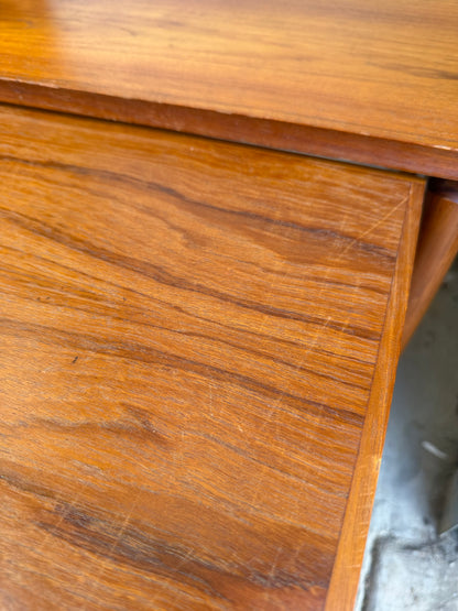 A close-up of a Noblett Mid-Century Floating Teak Nesting Table – Circa 1960s (Revive), highlighting its warm brown teak, natural grain, and sliding extension—features that reflect Danish-inspired design from the classic Noblett collection.