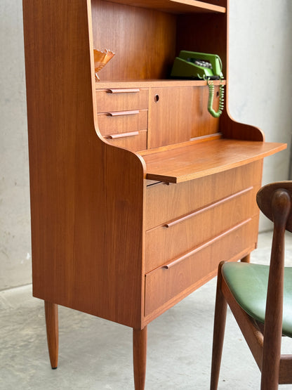 Danish Teak Bureau Bookcase Secretary Desk by Erik Petersen for EP Møbler, with drawers and a pull-down writing surface. On the shelf sit a green rotary phone and glass bowl; a green-cushioned wooden chair is partly visible in front.