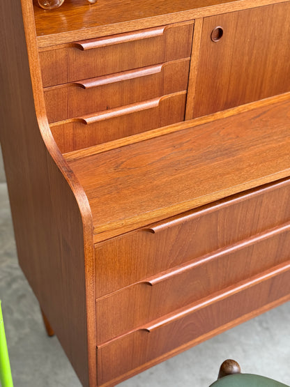 A close-up of the Danish Teak Bureau Bookcase Secretary Desk by Erik Petersen for EP Møbler, featuring four drawers, a sliding door compartment, smooth curved edges, and a warm teak finish inspired by Scandinavian design.