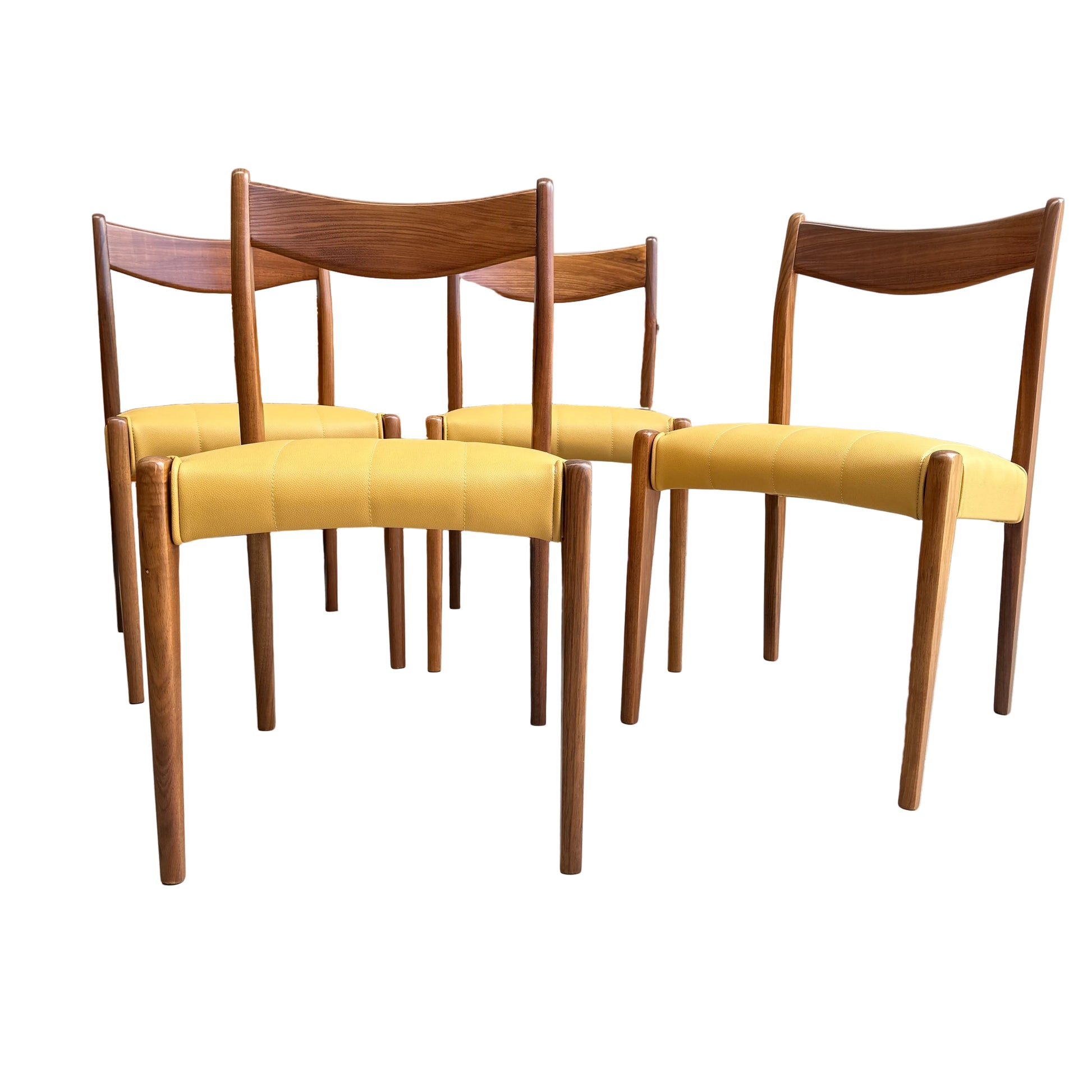 A set of four fully restored THB 'Stockholm' dining chairs (Rediscover), featuring yellow upholstered seats, is arranged on a concrete floor in front of a wooden cabinet and a light-colored wall.