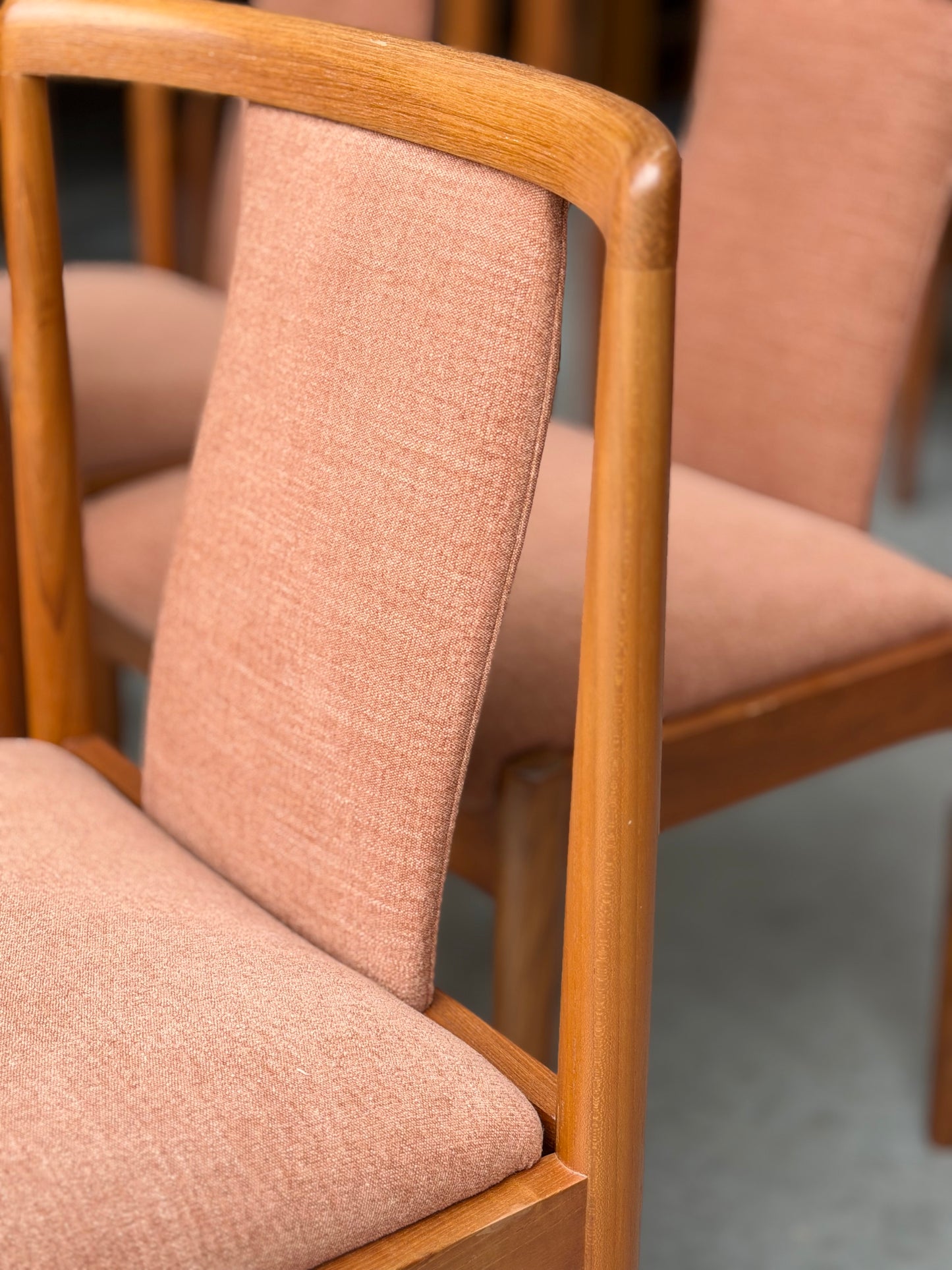 Close-up of two Parker 88 T Back Chairs, professionally restored with light brown upholstery and smooth curved wooden frames. Shown on a gray floor. Pre-order set of 4 with a 25% non-refundable deposit required.