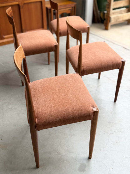 A set of four fully restored THB 'Milan' dining chairs (Rediscover) with light brown upholstered seats and curved wooden backs is arranged on a smooth concrete floor in a well-lit room.